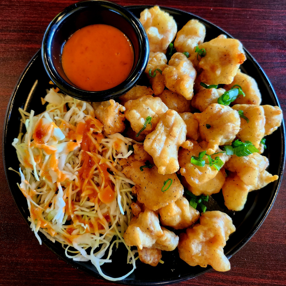 A&R Kitchen's fried shrimp with shredded cabbage and a side of orange dipping sauce.