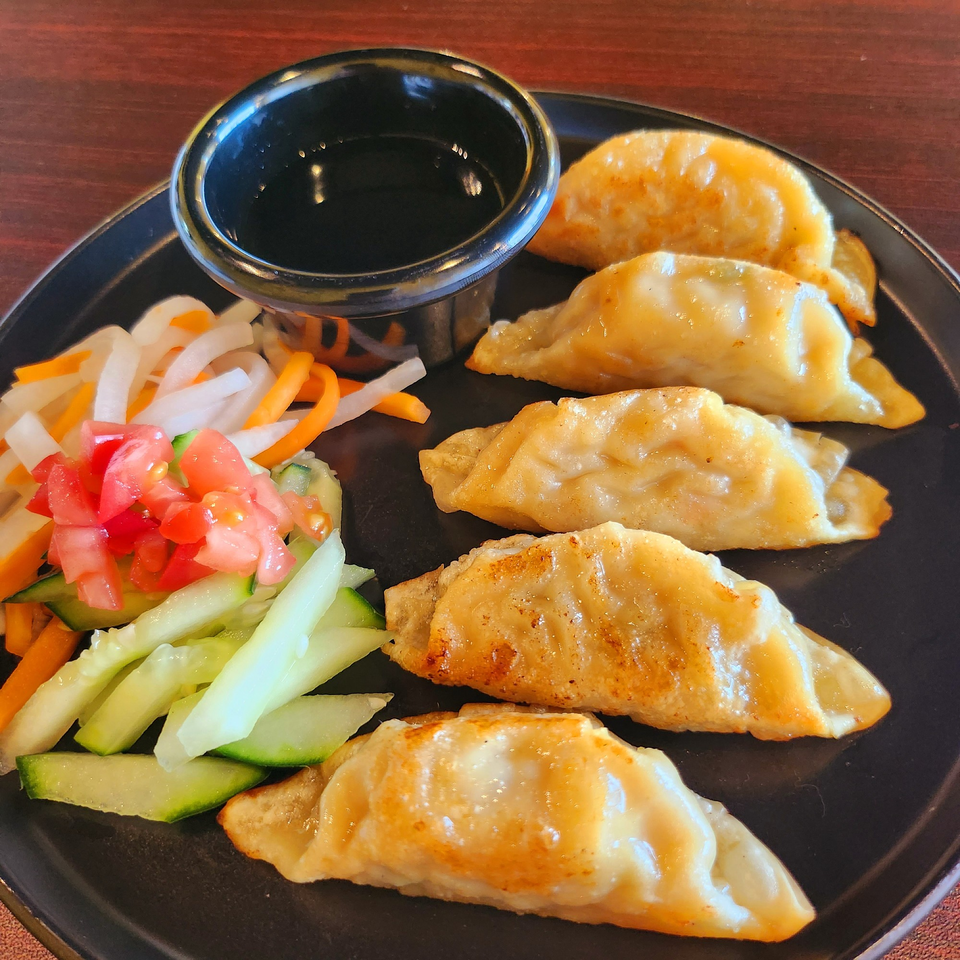 A&R Kitchen's pan-fried Vietnamese dumplings, with a side of pickled vegetables and dipping sauce.